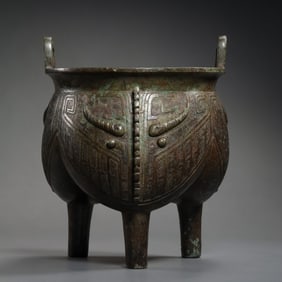 Chinese Shang and Zhou Dynasty bronze tripod stove with animal faces and two handles