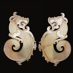 A pair of Chinese Han Dynasty jade dragon pendants