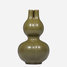An 18th-century Chinese Qing Dynasty tea-dust glazed tripod gourd-shaped vase bearing the
