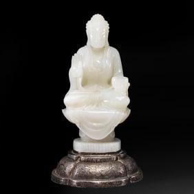 A white jade seated Buddha statue from the 8th century Tang Dynasty, inlaid with a pure silver lotus