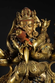 A MAGNIFICENT AND MASSIVE GILT-BRONZE FIGURE OF A TANTRIC DEITY IN YAB-YUMTIBET OR CHINA, MING