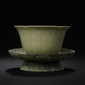 A RARE CELADON-GLAZED 'CLOUD' INCISED FOLIATE-RIM CUP ON A BRONZE STANDYUE WARE, TANG TO FIVE