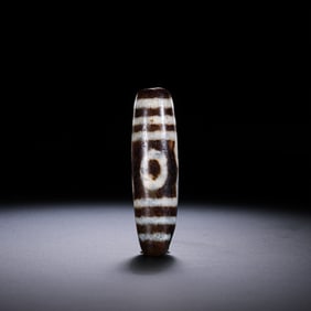 A RARE AND MAGNIFICENT MONUMENTAL 'THREE-EYED' DZI BEADHIMALAYAN REGION, TIBET, ANCIENT TO MEDIEVAL