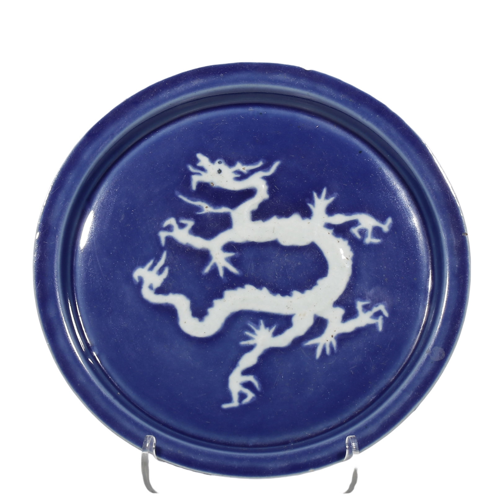 Ming Xuande Period, Sacrificial?Blue?Glazed Washer with Reserved?White Dragon Motif: Dimensions?D.16cm (0.525ft) Condition & Provenance?Overall intact, rich even sacrificial?blue glaze, minor age?related wear on rim, heavy earth patina and usage marks on unglazed sandy base, no cracks