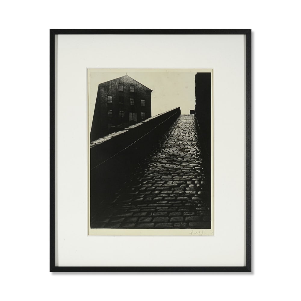 BILL BRANDT, COBBLED STREET: Medium: Gelatin Silver Print Image Dimensions: 9 x 6 7/8 in (23 x 17.6 cm) Framed Dimensions: 14 x 11 5/8 in (35.6 x 29.6 cm) Signature: Signed in pencil by Bill Brandt at the lower right Description: