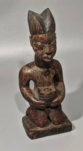 Exceptional Yoruba Master Carver's 'Modello': Particularly early, likely mid 19th century, a scarified crowned male, kneeling, holding a sacrificial vessel. This quite ancient figure, is adorned with green and red coloring. The natural wood with