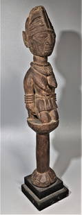 A Classical Antique Yoruba Staff, Kneeling Figure: This hand held ceremonial staff figure is circa 1900 in original natural wood surface. Strong carving with age splits through the right side of the head, between the breasts and at the central base.