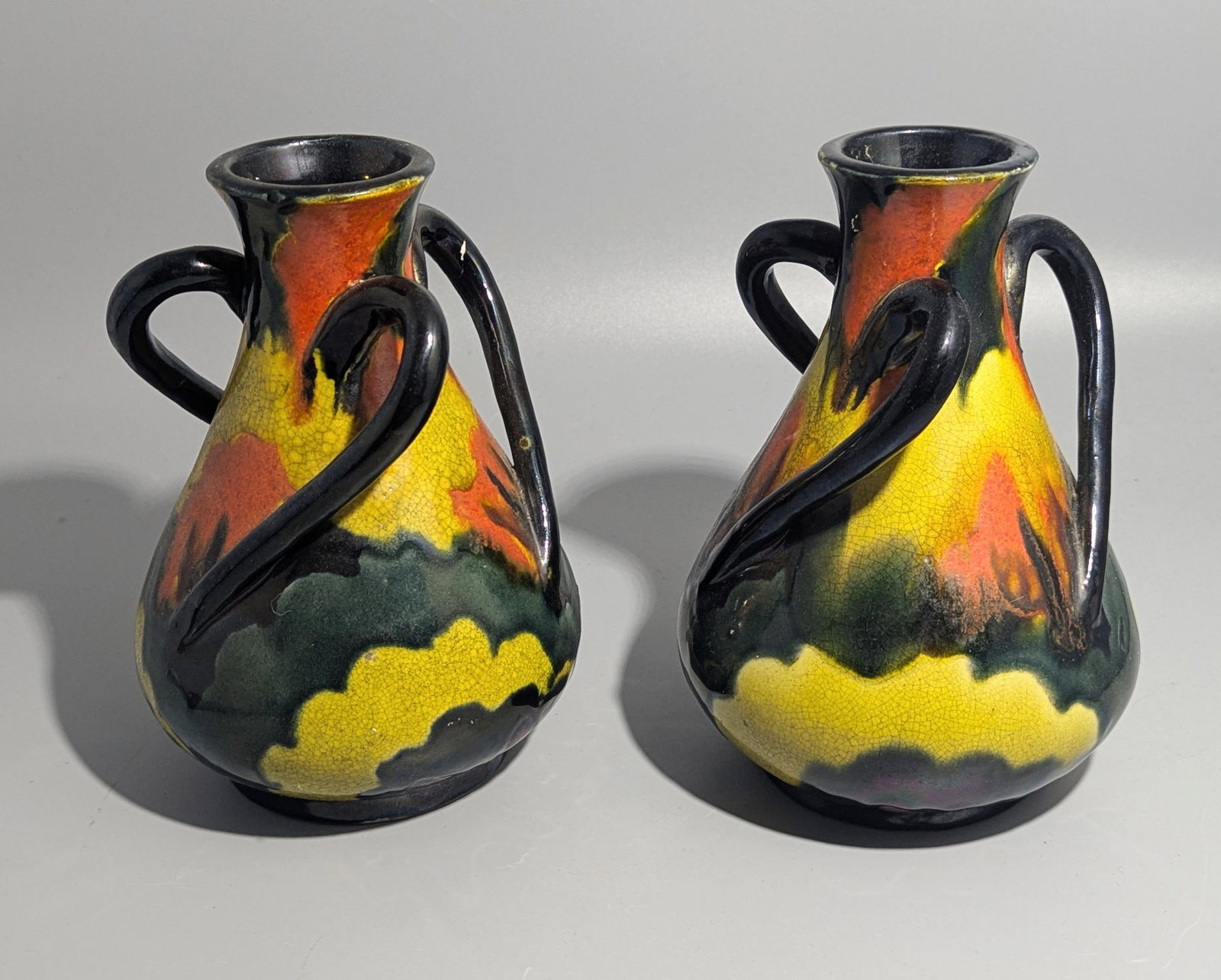 Pair of Awaji Pottery Four-Handled Flambe Crackle-Glazed Vases, Japan: An attractive matched pair of Japanese Awaji art pottery cabinet vases, each of baluster form with four applied loop handles and decorated in vibrant flambe crackle glazes of yellow, orange, green, an