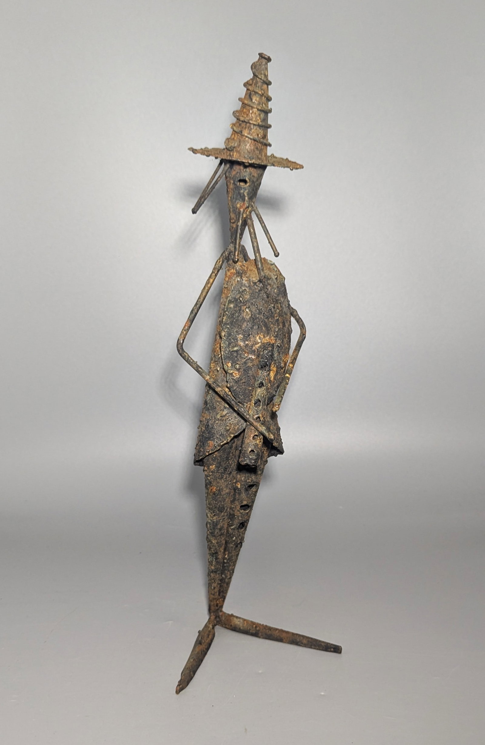 Giovanni Grittani Attributed Wrought Iron Figural Sculpture: Attributed to Giovanni Grittani, Italian, a distinctive hand-worked and welded wrought iron sculpture depicting an elongated standing figure in a tall conical hat. Constructed from pierced and