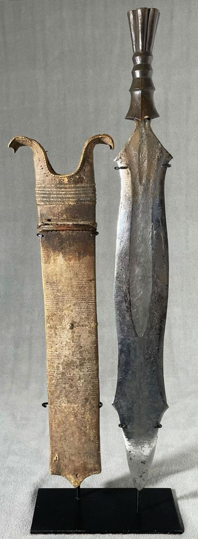 African Congo Salampasu Court Sword & Scabbard Display: Country of Origin: Presently Democratic Republic of the Congo (DRC); originates from the era of the Belgium Congo (1908-1960) Early 20th Century Salampasu court sword & scabbard. Sword with hand-forge