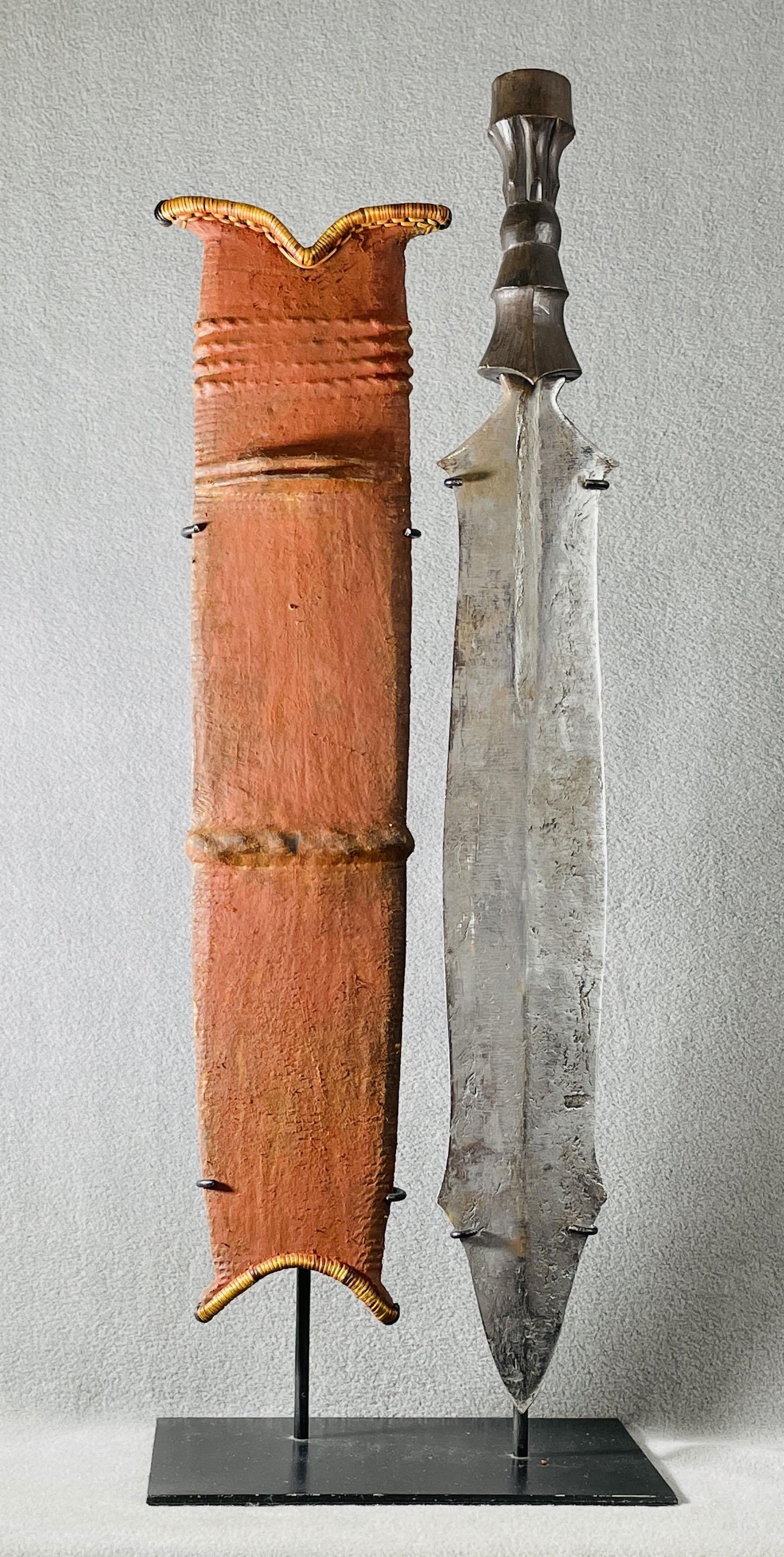 African Congo Salampasu Court Sword & Scabbard Display: Country of Origin: Presently Democratic Republic of the Congo (DRC); originates from the era of the Belgium Congo (1908-1960) Early 20th Century Salampasu court sword & scabbard. Sword with hand-forge