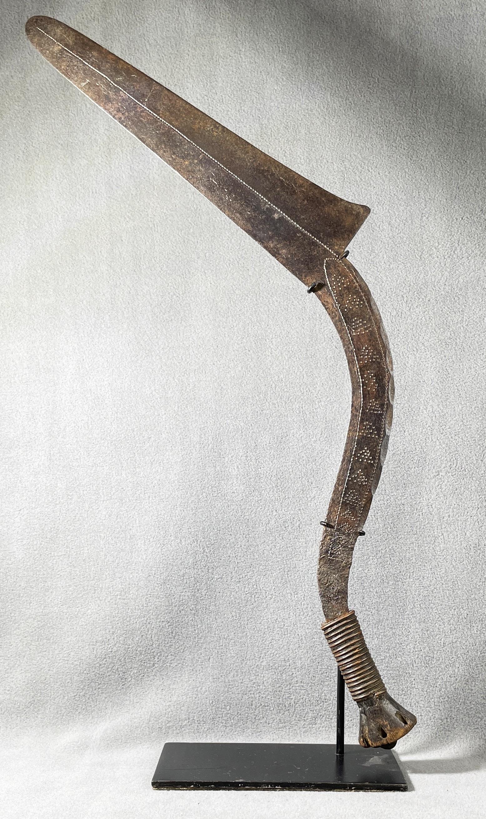 African Congo Ngombe Throwing Knife Display Included: Country of Origin: Presently Democratic Republic of the Congo (DRC); originates from the era of the Belgium Congo (1908-1960) Early 20th Century metal throwing knife with incised detailing and a fiber