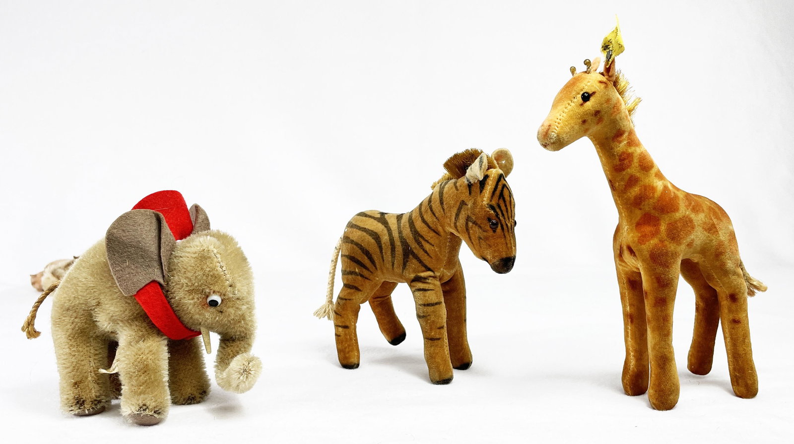 Collection of Vintage German Steiff Circus Animals One: Collection of three vintage Steiff circus animals including a giraffe, zebra and elephant. Giraffe has Made in Germany tag. Elephant tag states "Made in US-Zone Germany." Wear commensurate with age in