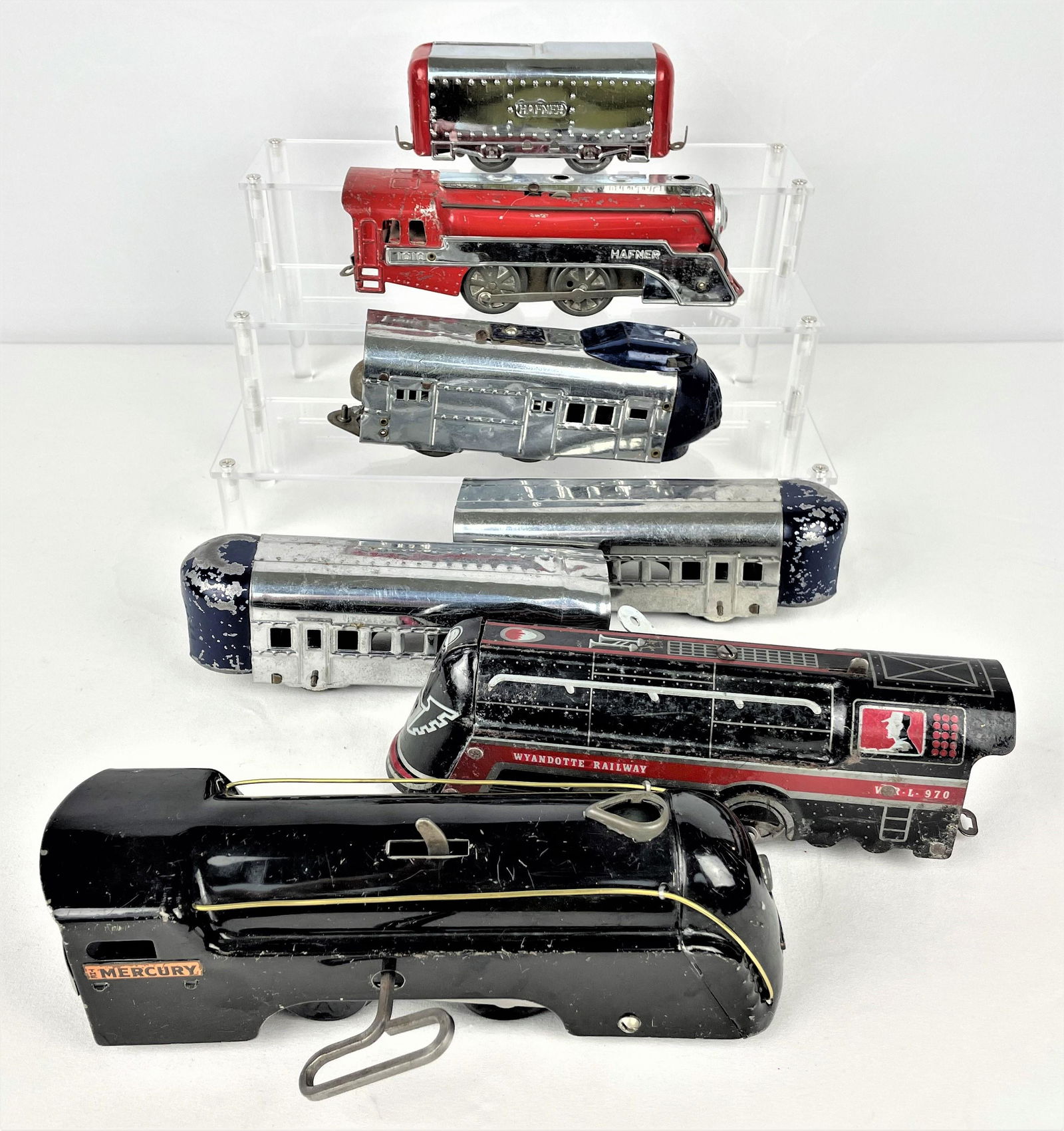 Group Early Wind-Up Trains Hafner Marx: Group of early vintage wind-up locomotive trains including a Hafner 1010 red and chrome engine and box car, an unidentified blue and chrome set with engine and two observation cars, a Marx Mercury eng