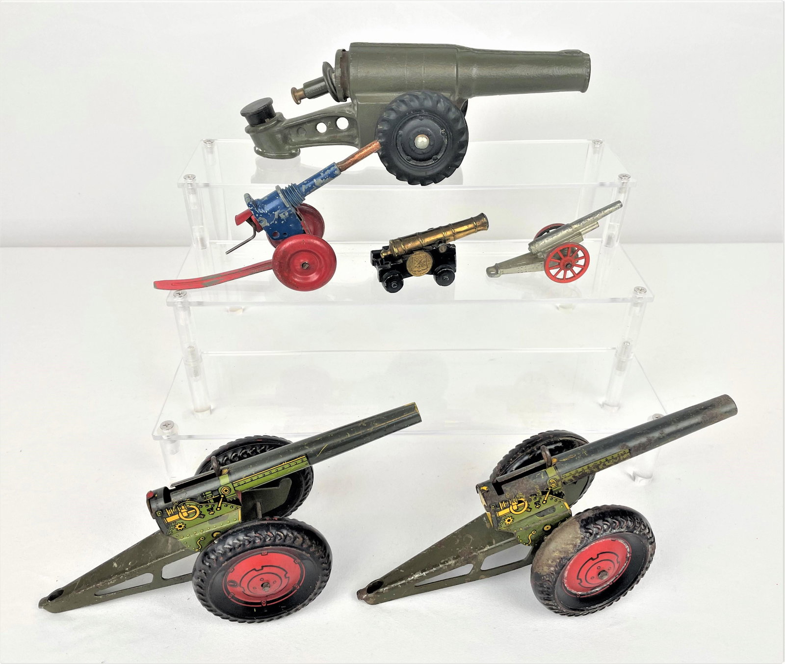 Group Cannons Howitzers Field Guns: Group of six (6) toy cannons/howitzers/field guns including a cast iron piece, two vintage Marx tin litho pieces, a vintage metal blue and red piece, and two smaller metal pieces, one marked "Fort Bra
