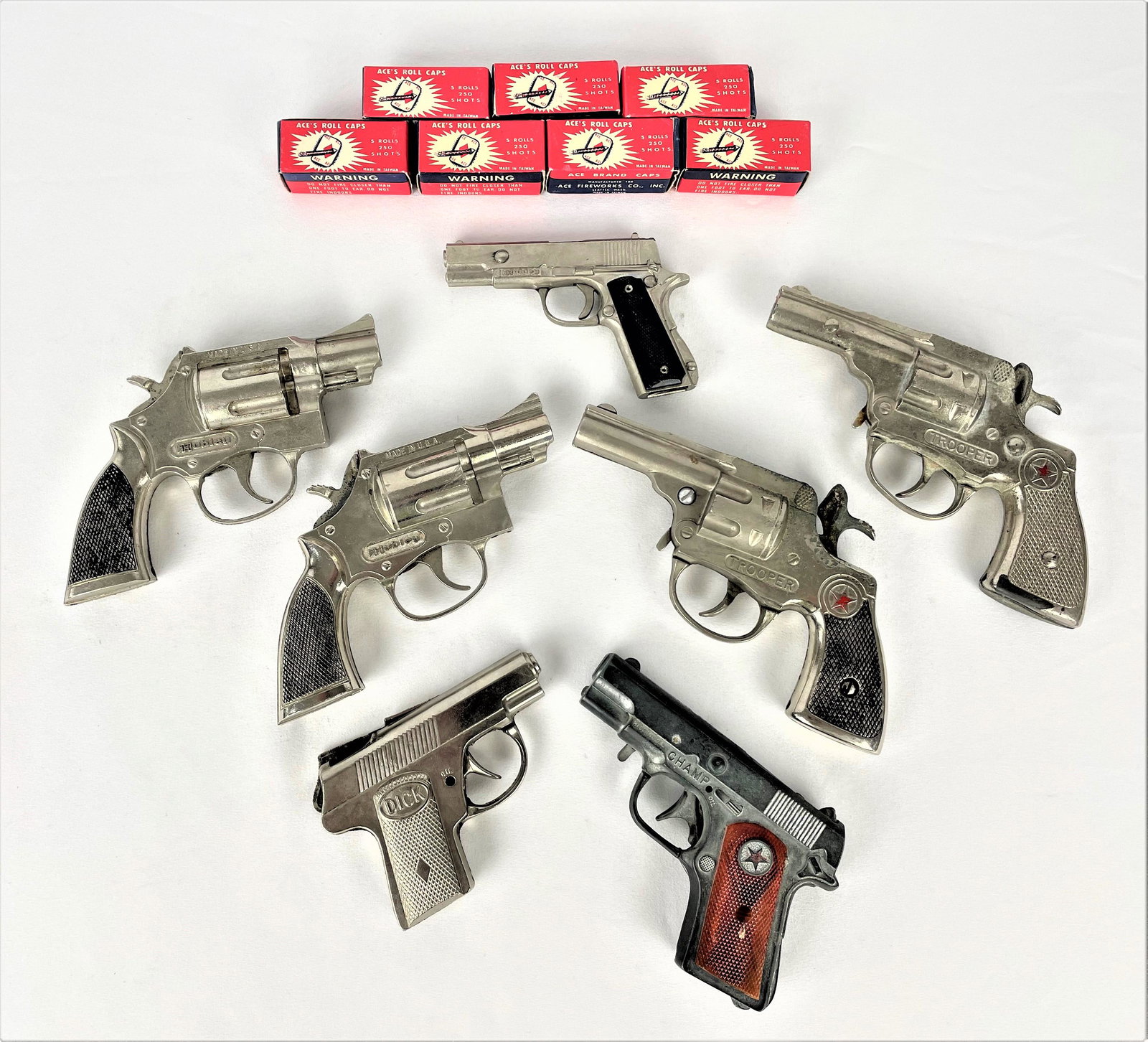 Group Hubley Capguns w/ Ammo Dick Tracy: Group of seven (7) vintage diecast pistol and handgun style capguns including a Dick Tracy, Champ smaller pistol and four Trooper handguns. Includes seven unused rolls of Ace's roll cap ammo in it's o