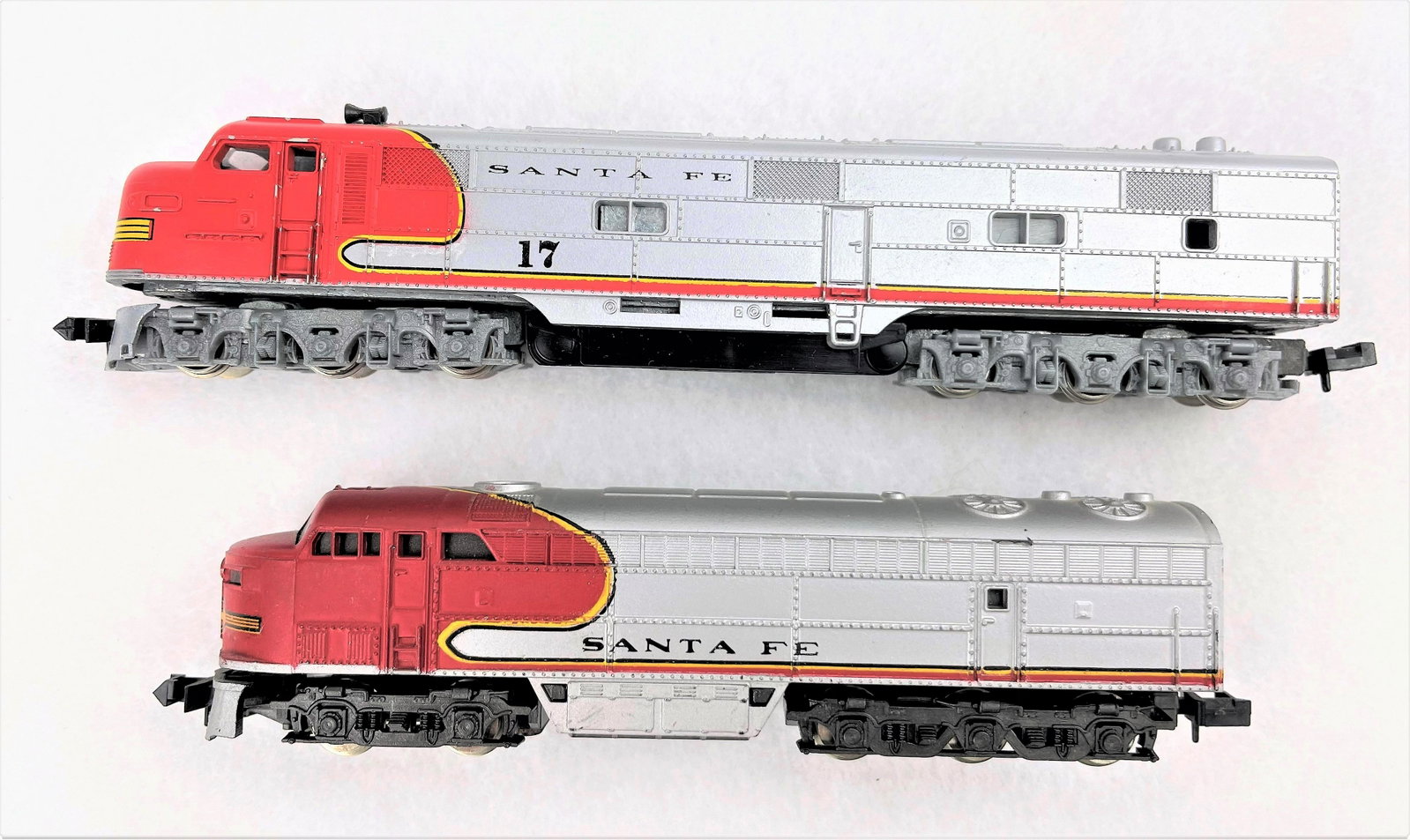 Santa Fe N Scale Train Engines & Passenger Cars: Santa Fe N scale train engines and passenger cars including a Con-Cor engine, an Atlas engine and six passenger/baggage cars by various makers. Untested. Light vintage wear including some light rubbin