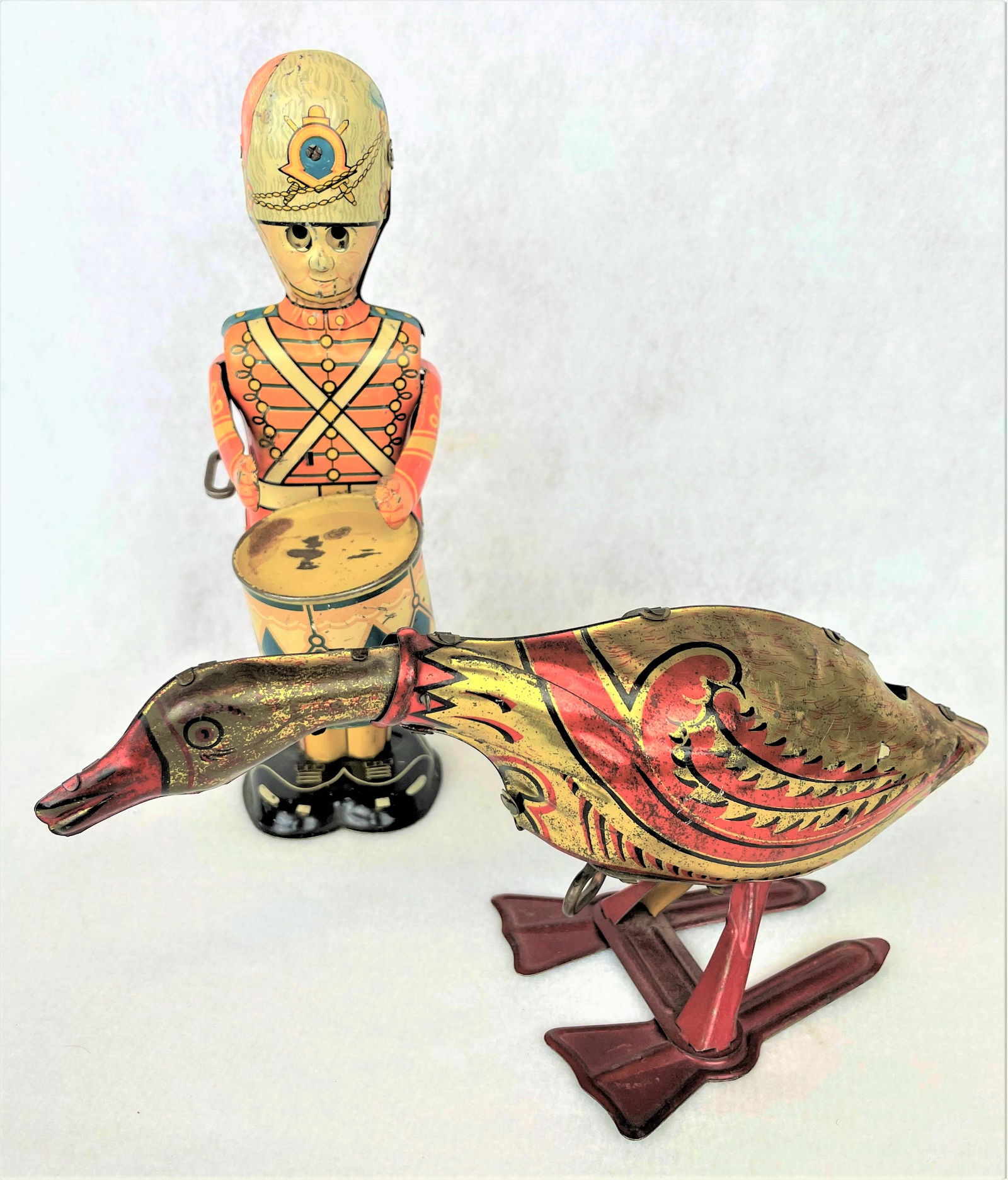 Marx Tin Litho Toys 1926 Golden Goose: Two (2) vintage Marx tin litho wind-up toys including a 1926 Golden Goose and 1940s George the Drummer with movable eyes. Vintage wear throughout including scratching and paint loss. See photos for co