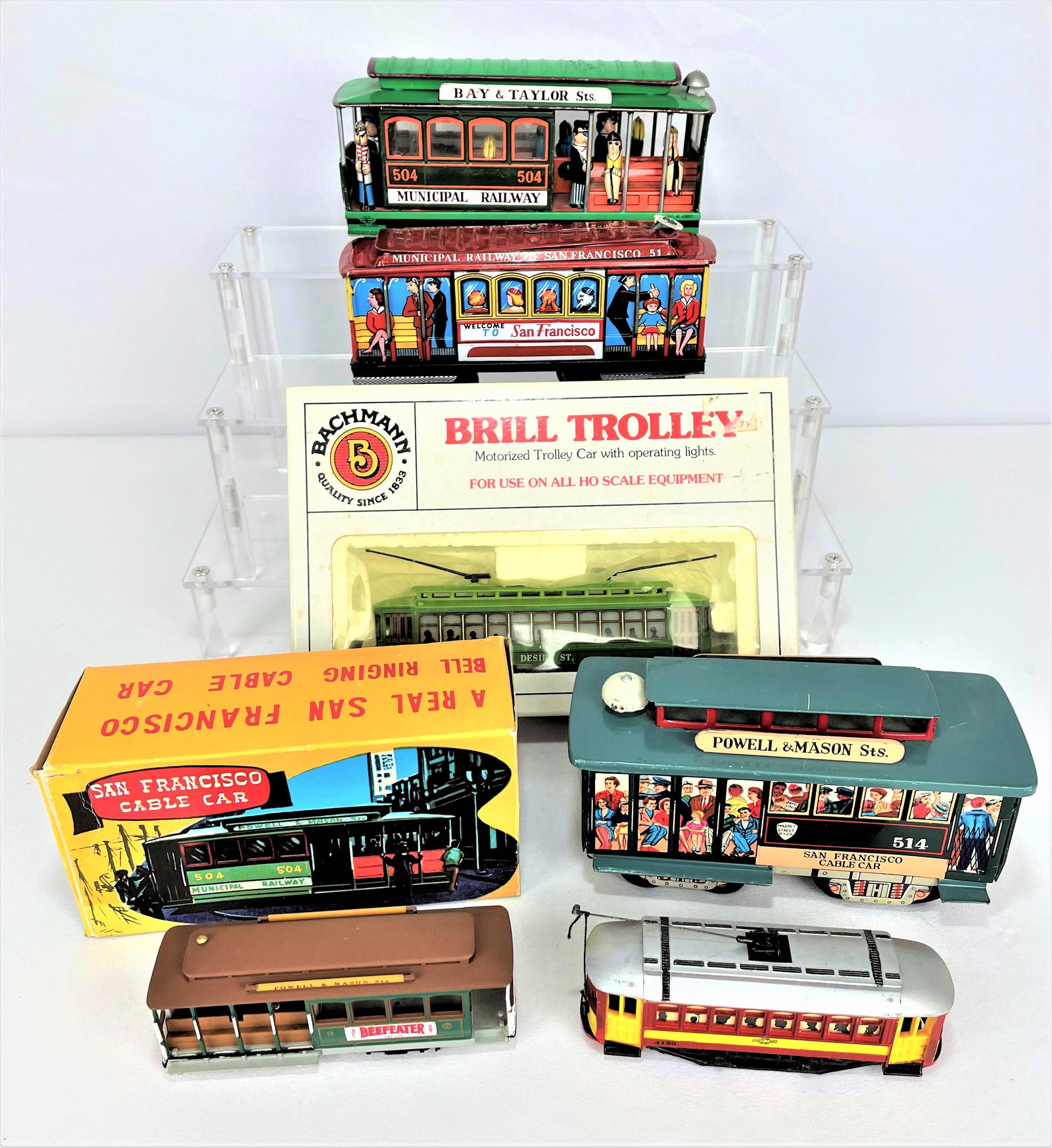 Group San Francisco Toy Cable Cars: Group of seven (7) San Francisco toy trolley cable cars. Tin litho and more. Two in original boxes. Light wear. See photos for condition details. Largest 7" long.