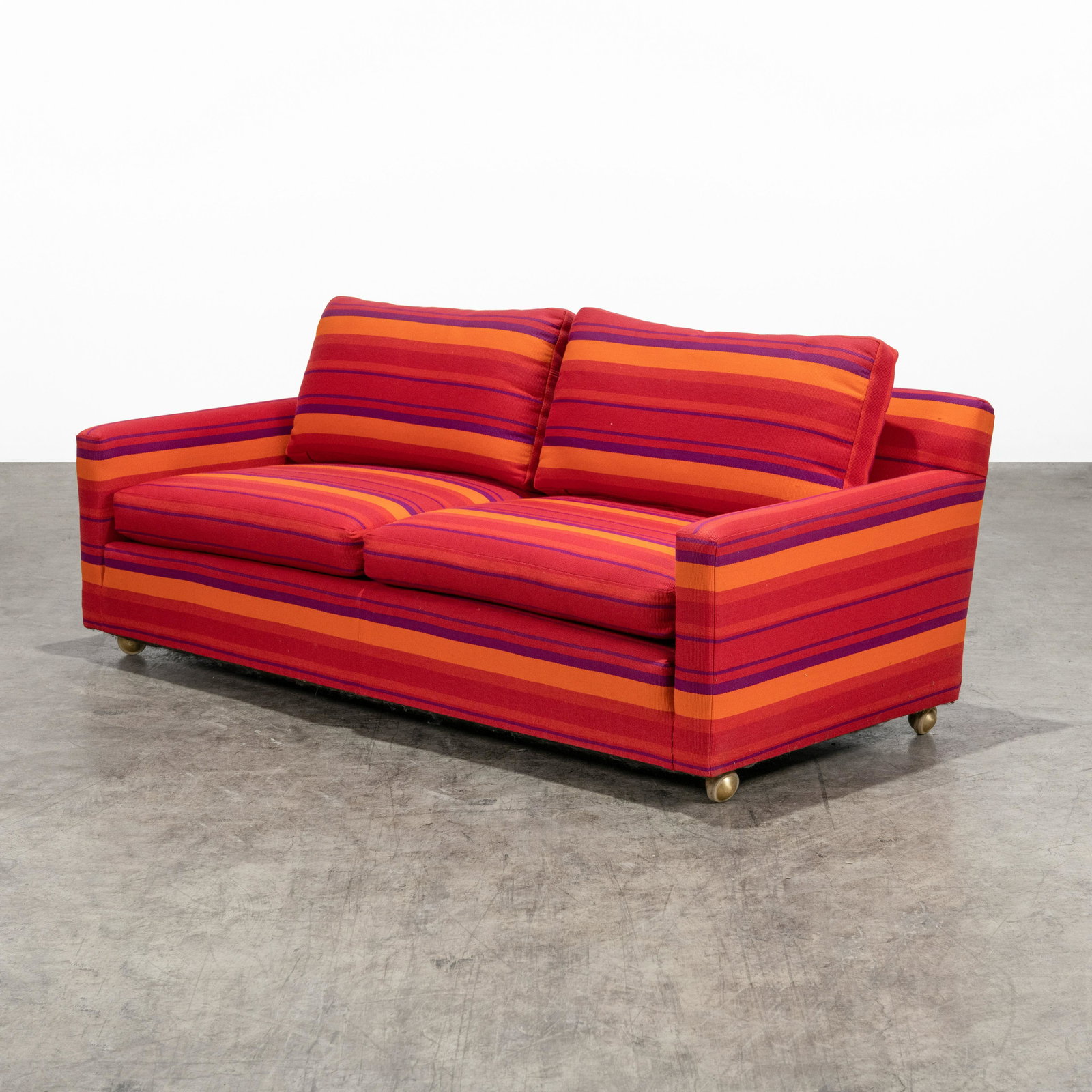 Alexander Girard - Sofa: An Alexander Girard upholstered sofa on casters. Unmarked. 29 x 72 x 35 . All measurements are in inches.