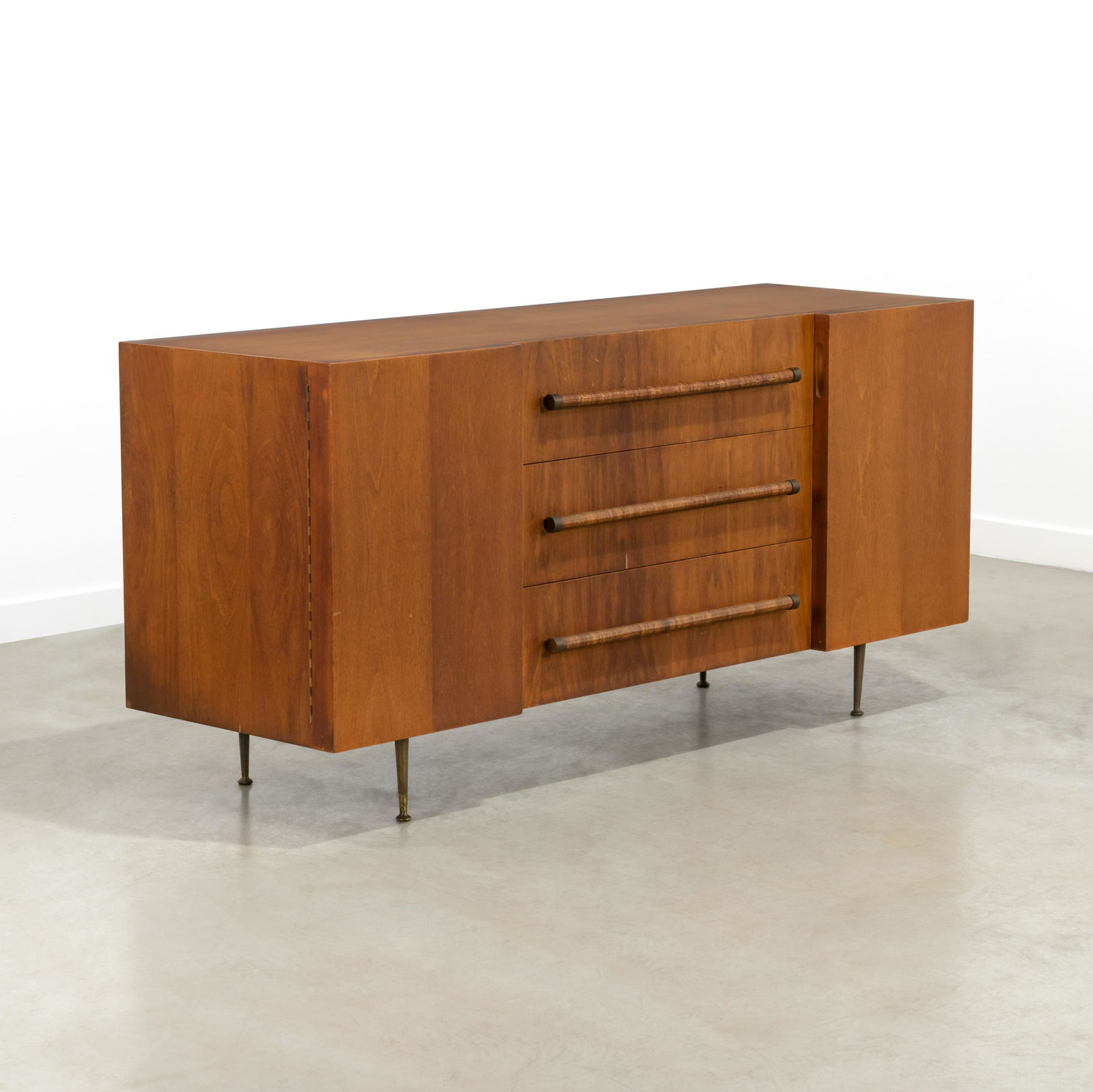 T. H. Robsjohn Gibbings - Credenza: A vintage credenza by T. H. Robsjohn Gibbings with caned pulls and brass legs. 32.5 x 67.5 x 21.5 . Measurements are in inches. (Height x Width x Depth)