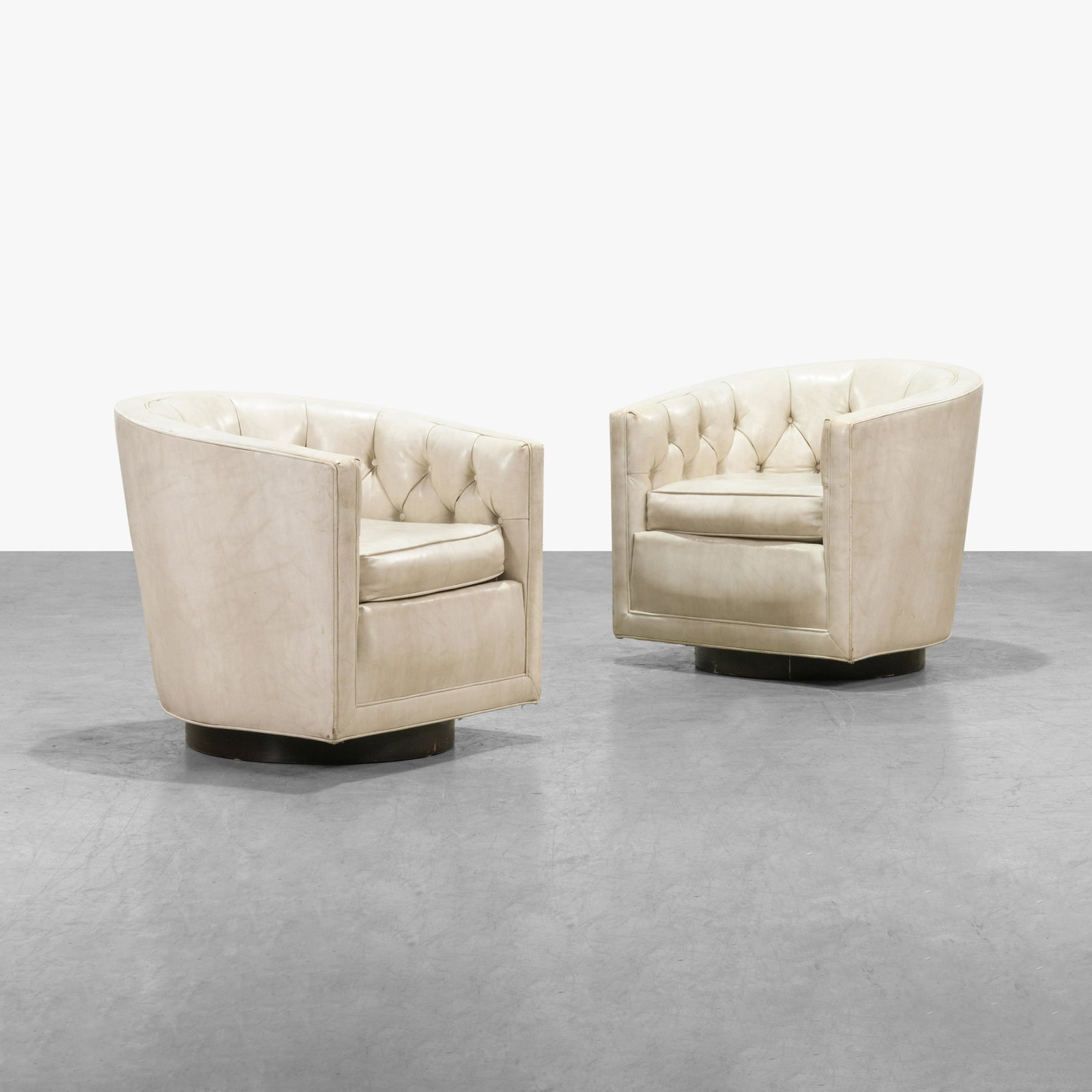 Edward Wormley - Swiveling Tub Chairs: A pair of swiveling tub chairs by Edward Wormley for Dunbar in tufted vinyl upholstery 27 x 30 x 21. All measurements are in inches.