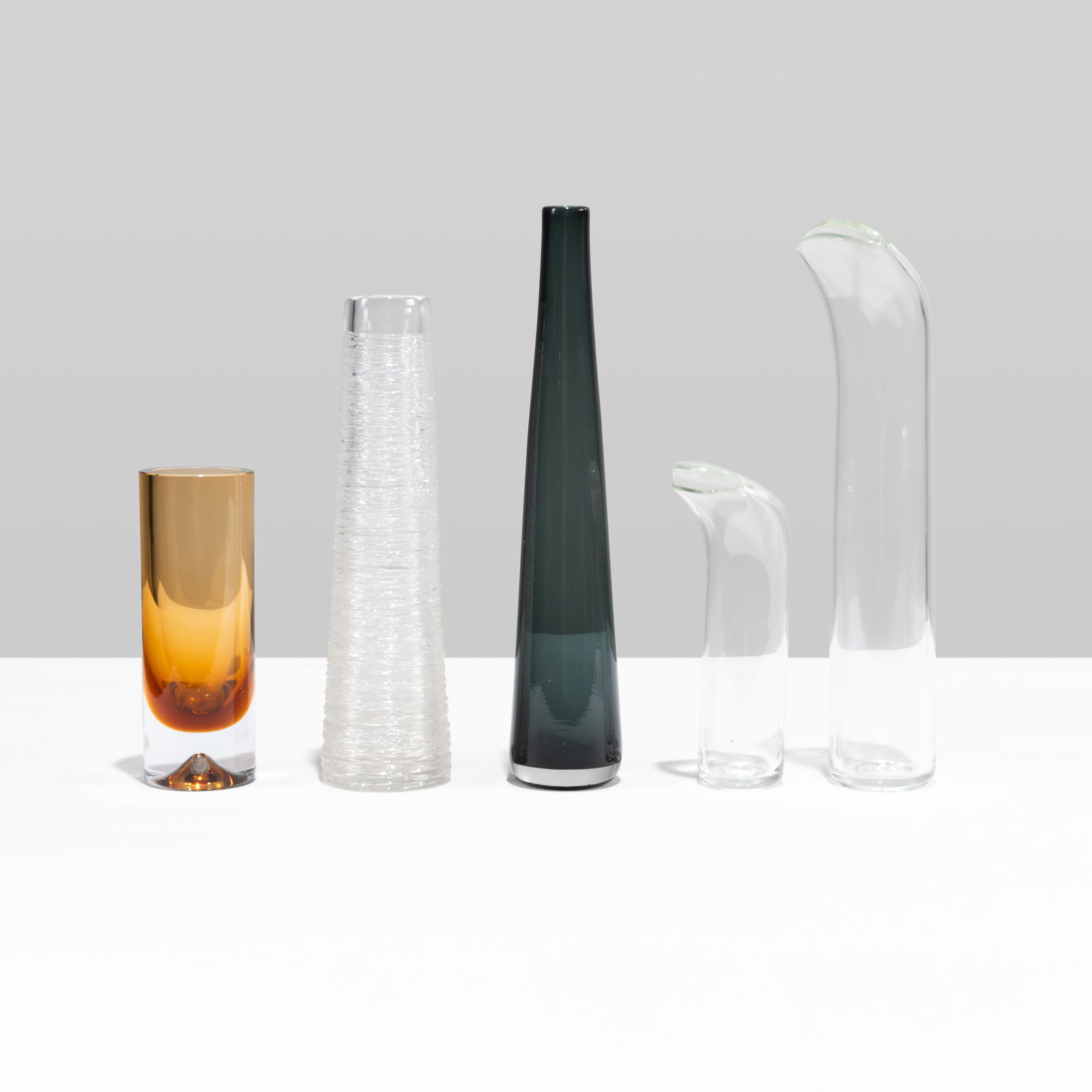 Art Glass Group: A group of miscellaneous art glass vases including a spun crystal vase by Bengt Edenfalk, an amber glass vase by Magnor, Norway, a tall and tapered cobalt black vase and two similar glass vases with c