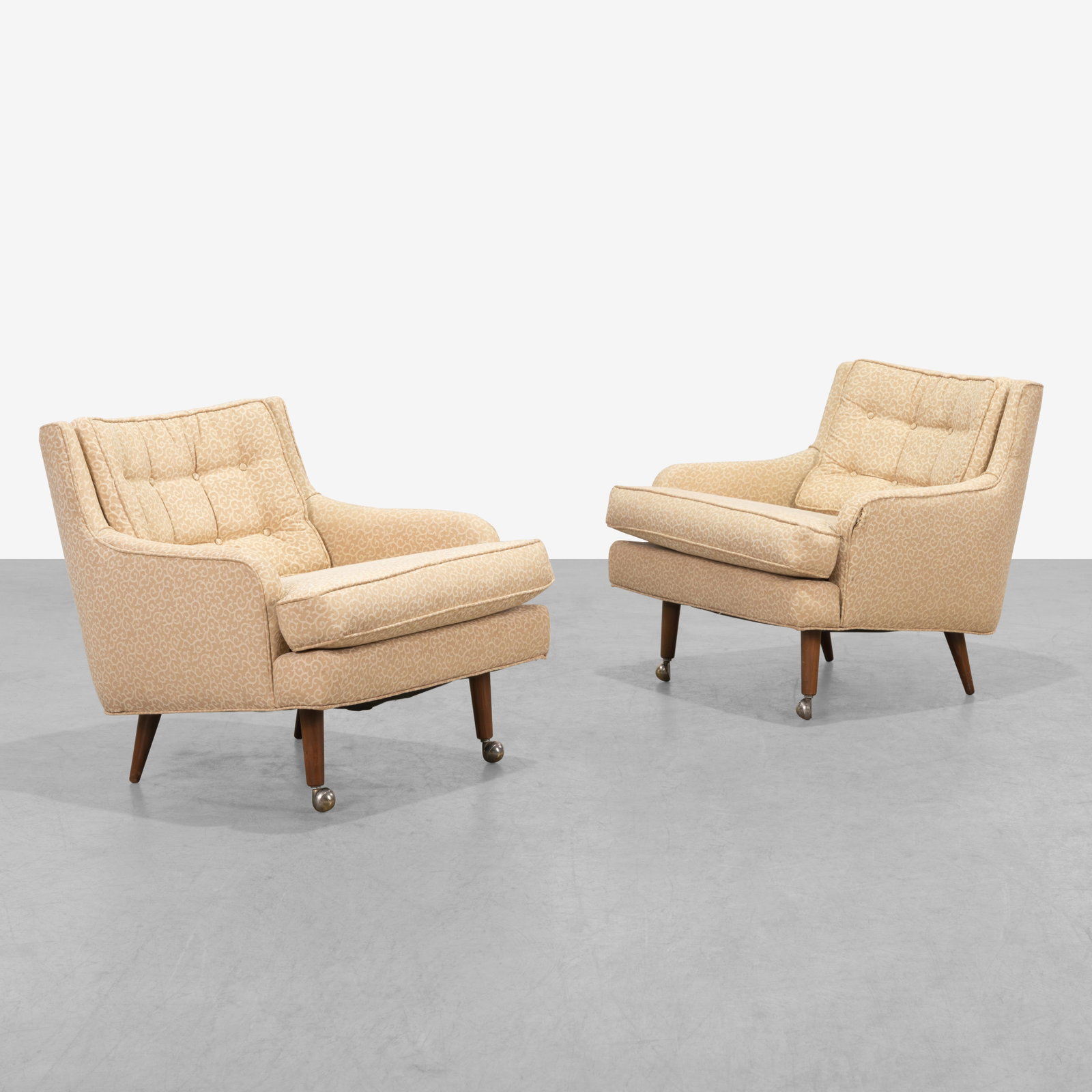 Vintage Club Chairs: A pair of low club chairs with walnut legs and casters.