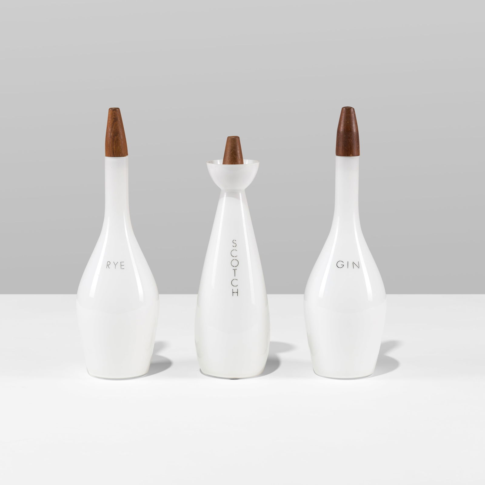 Italian Decanter Set: A set of three glass and teak decanters by Raymor / Kastrup. All measurements are in inches. Height x Width x Depth