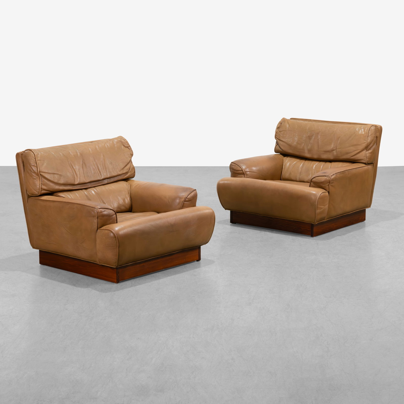 Arne Norell - Lounge Chairs: A pair of leather 'Mexico' club chairs on wooden pedestal bases by Arne Norell, Sweden. All measurements are in inches. Height x Width x Depth