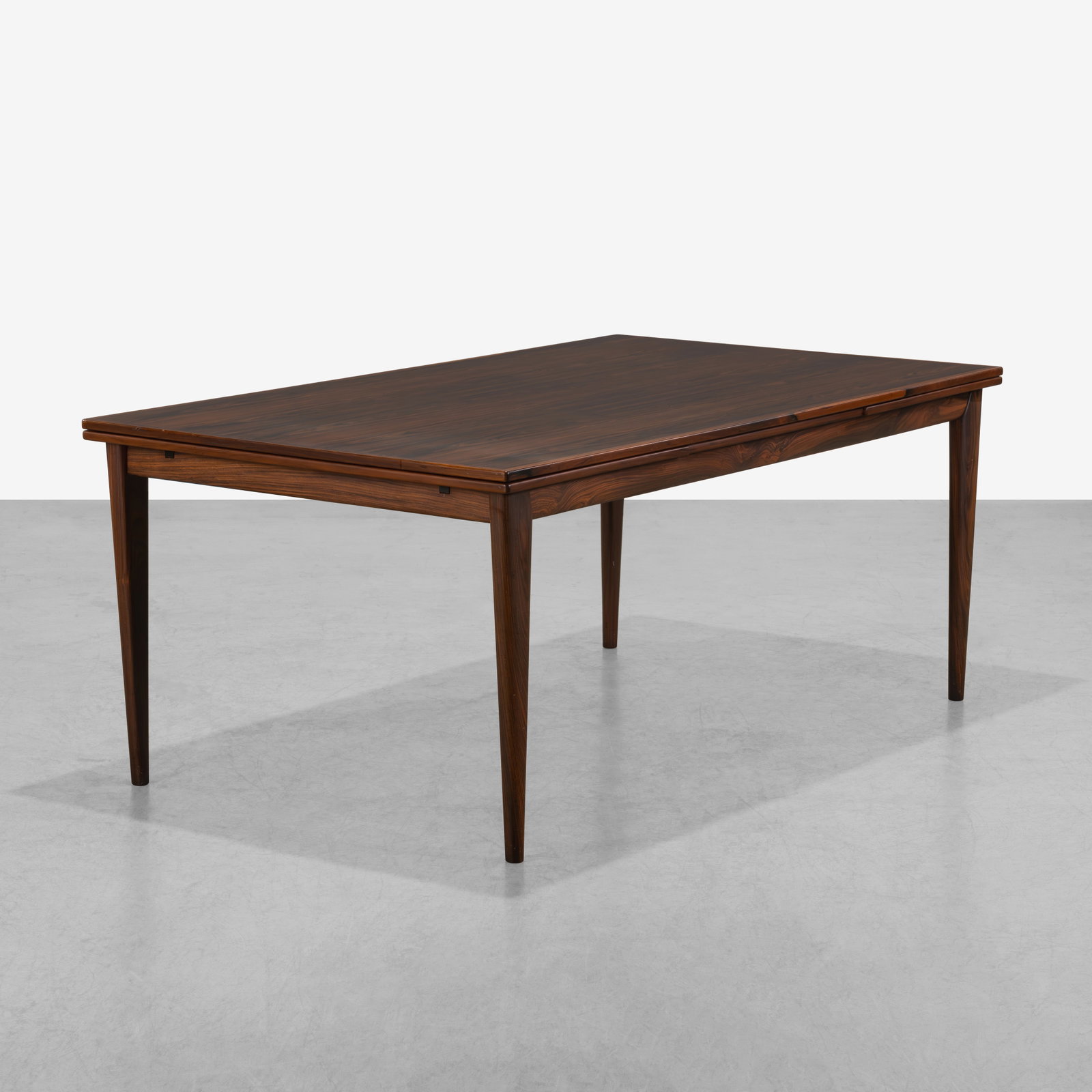Rosewood Dining Table: A Danish rosewood dining table with pull out leaves. Leaves 22.75" All measurements are in inches. Height x Width x Depth