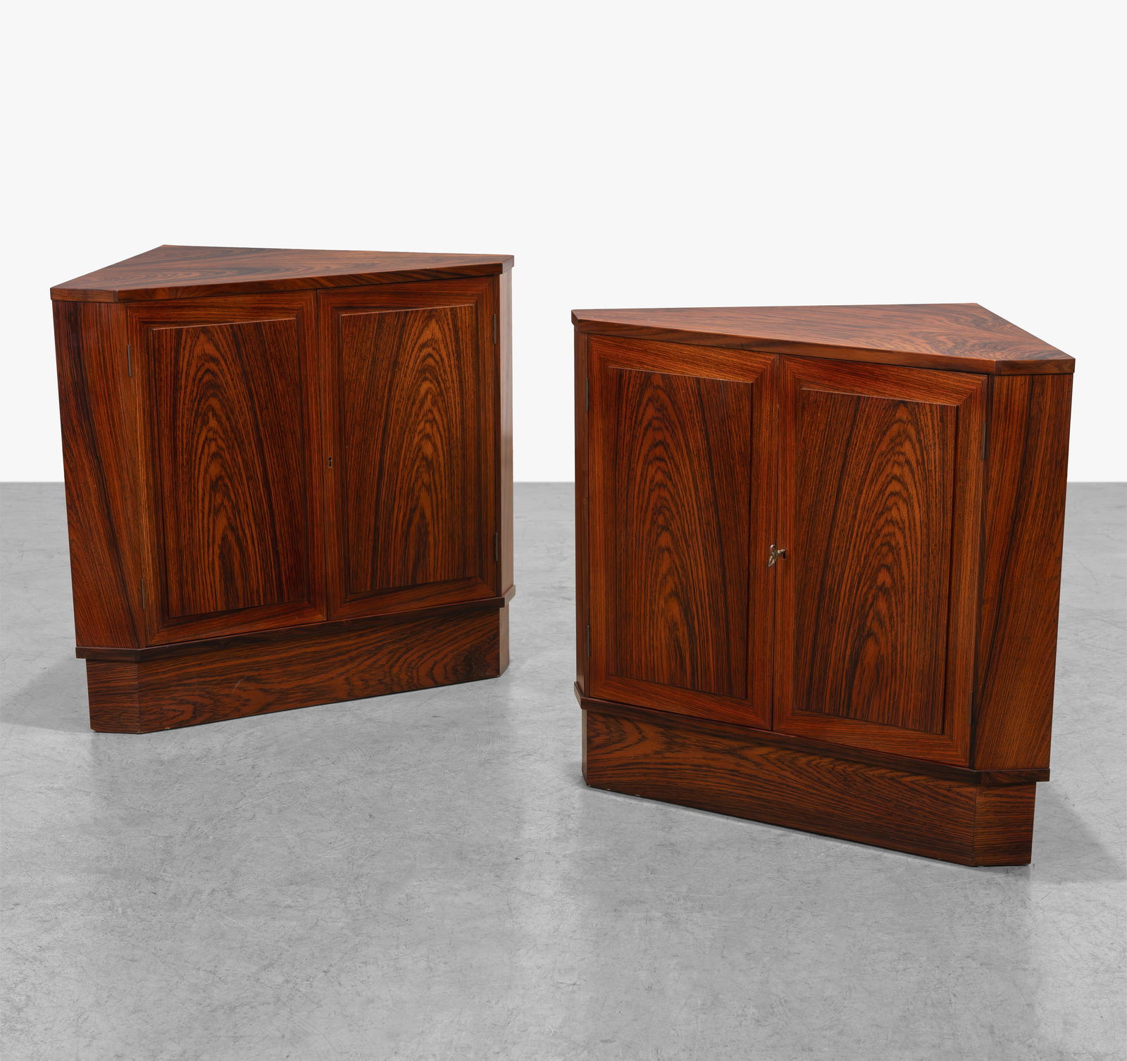 Danish Rosewood Corner Cabinets: A pair of Danish rosewood corner cabinets. Each contain one interior shelf.
