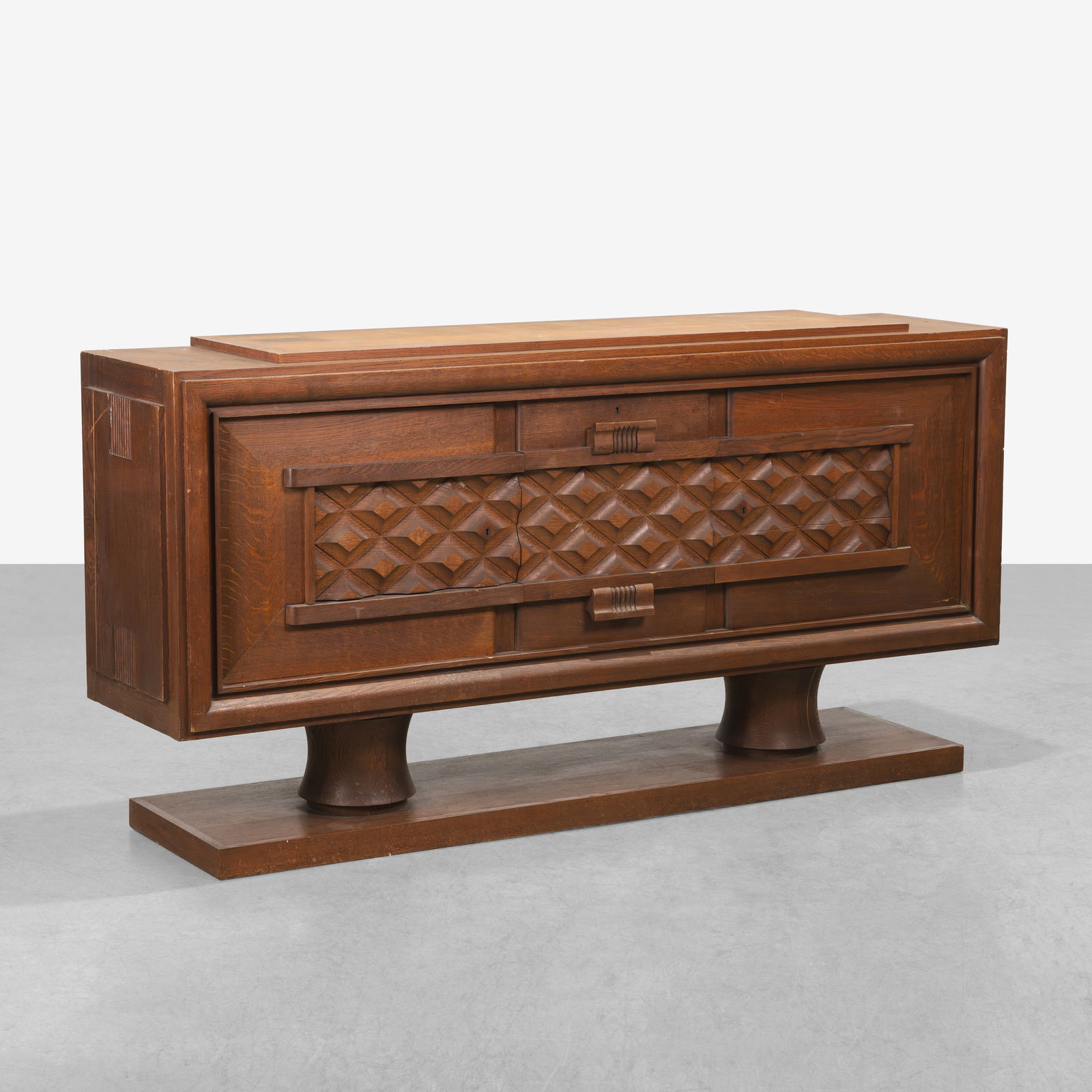 Charles Dudouyt (Attr.) - Sideboard: A large oak sideboard attributed to Charles Dudouyt.Center top door drops open to expose a dry bar with shelves. Hinges are damaged for drop down door. All measurements are in inches. Height x Width x