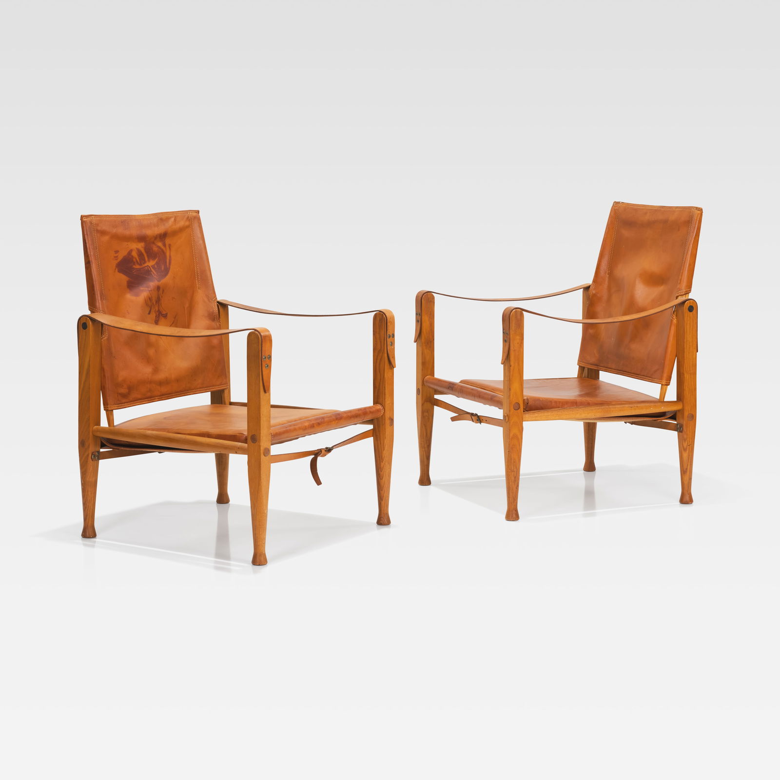 Kaare Klint - Safari Chairs: A pair of leather and ash 'Safari' chairs by Kaare Klint for Rud. Rasmussens Snedkerier. All measurements are Height x Width x Depth. September 26th Fire On September 26, a minor printer-related fire