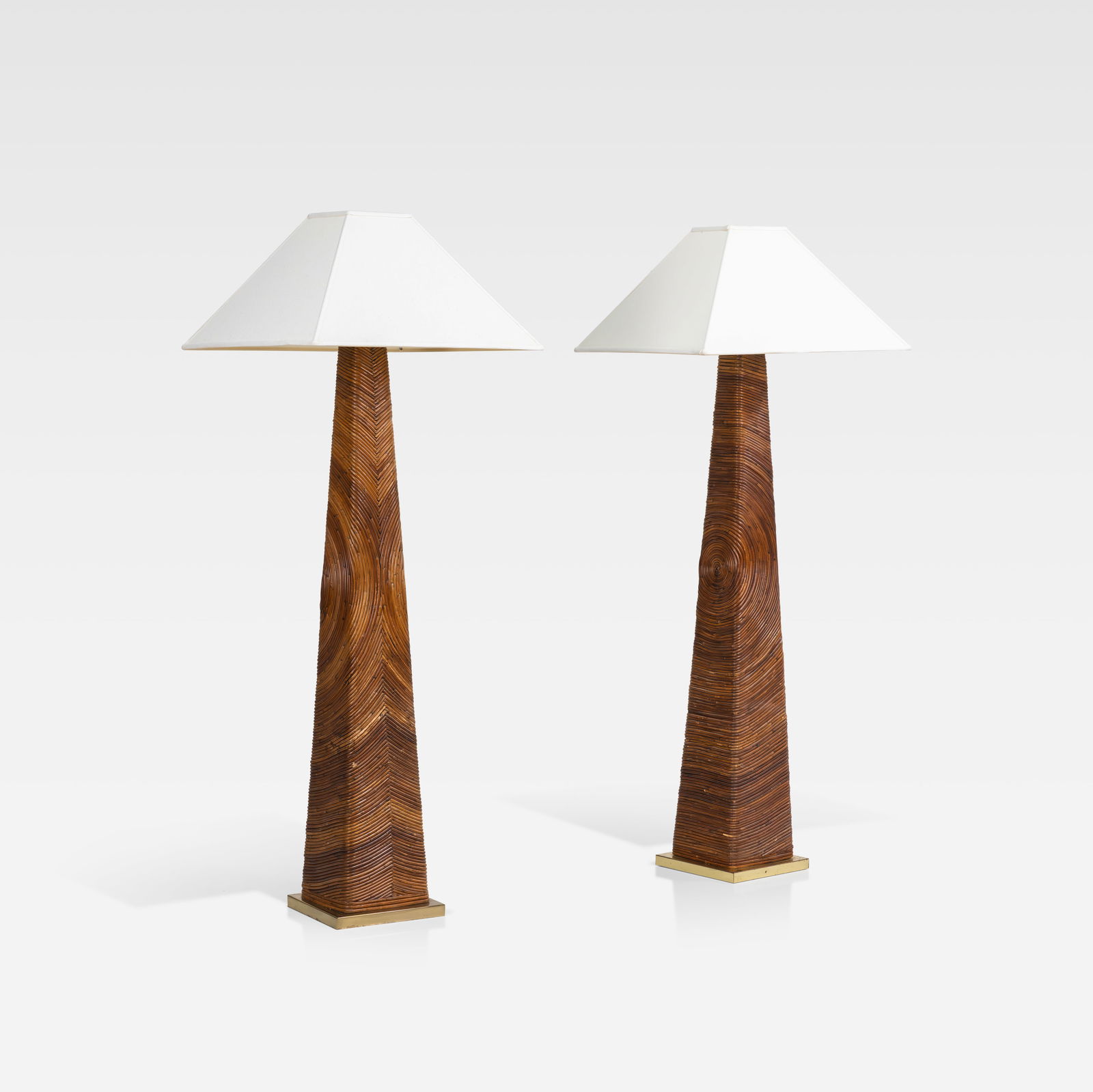 Pencil Rattan Floor Lamps: A pair of pencil rattan floor lamps in the manner of Gabriella Crespi. Dimensions listed are for lamp body only. Shade - 11.75 x 22.25 x 22.25. All measurements are Height x Width x Depth.