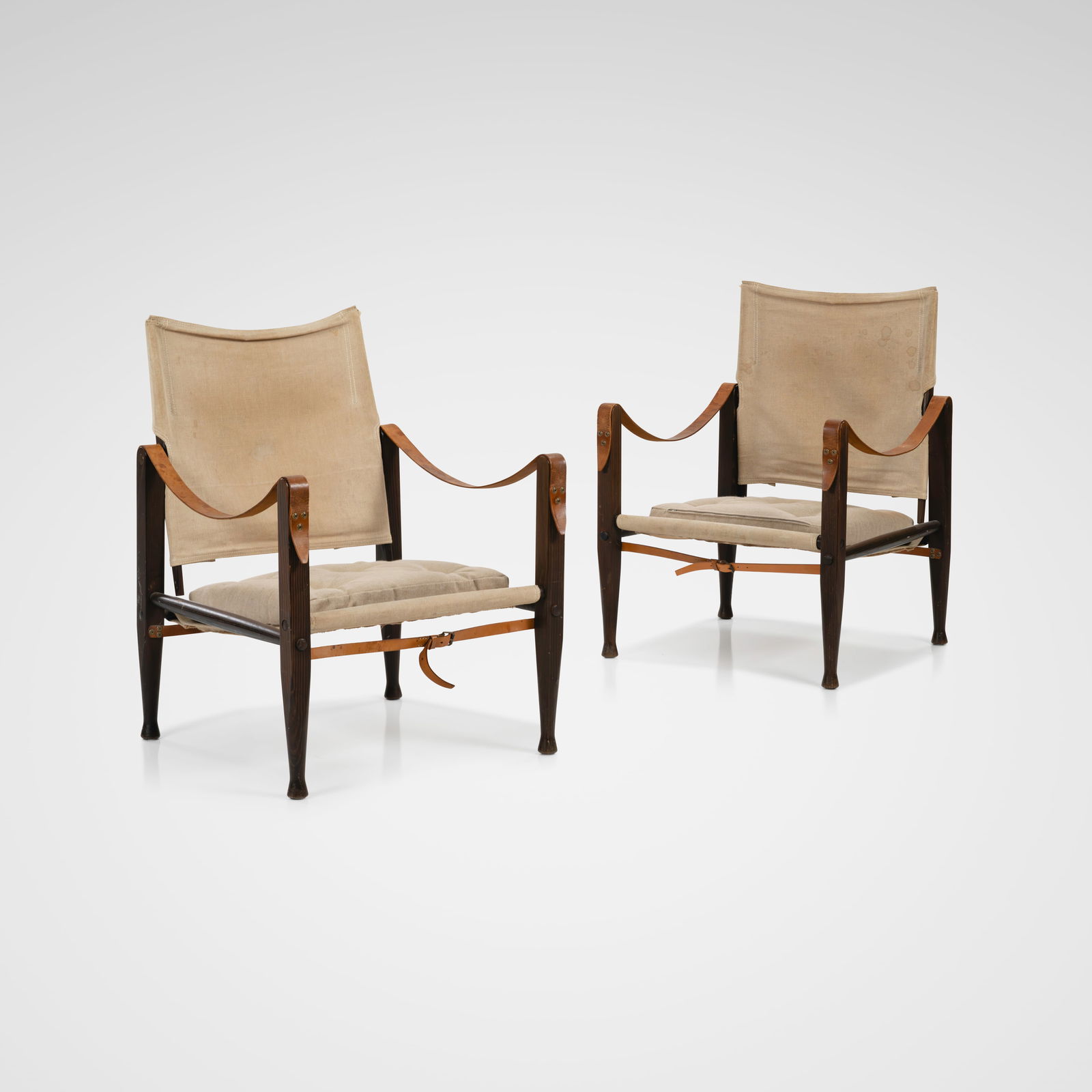 Kaare Klint - Safari Chairs: A pair vintage 'Safari' chairs with canvas upholstery and leather straps by Kaare Klint for Rud. Rasmussen, Denmark. All measurements are Height x Width x Depth.