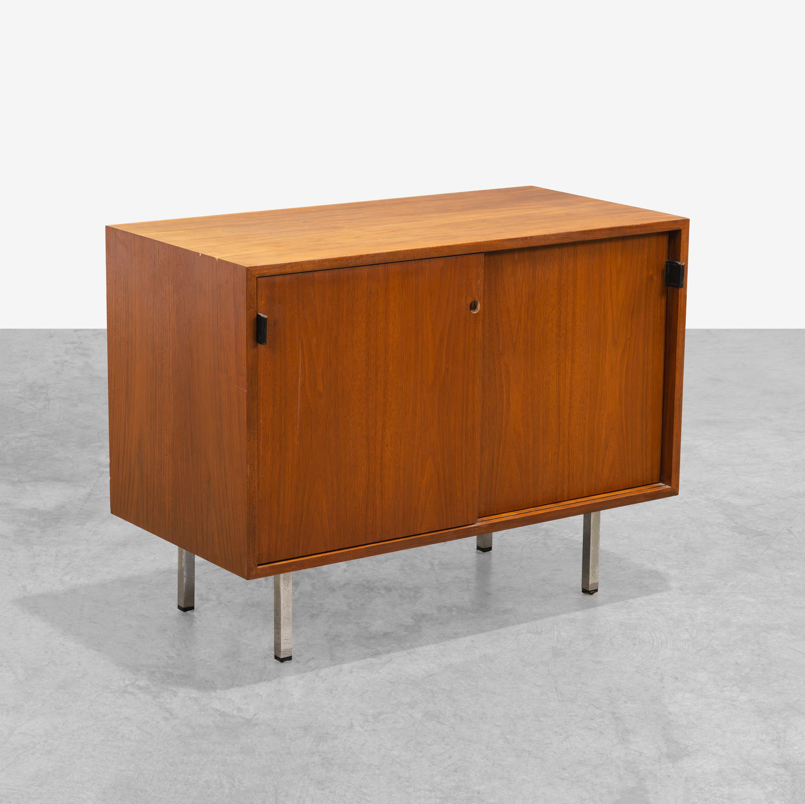 Florence Knoll - Compact Credenza: A walnut compact credenza by Florence Knoll. Both sides contain a shelf and pull-out file. All measurements are Height x Width x Depth.