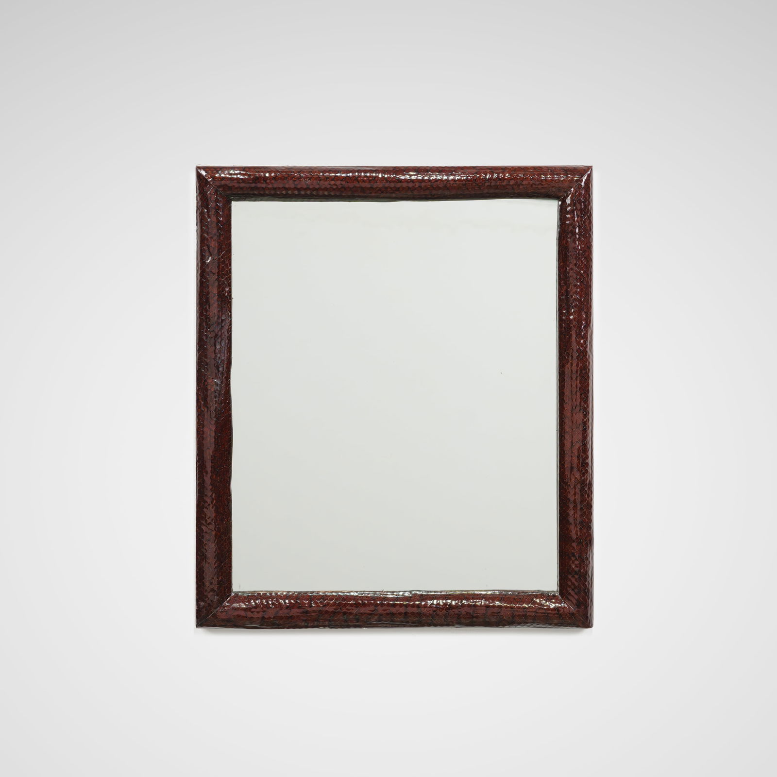 Snakeskin Mirror: A mirror wrapped in snakeskin in the manner of Karl Springer. All measurements are Height x Width x Depth.