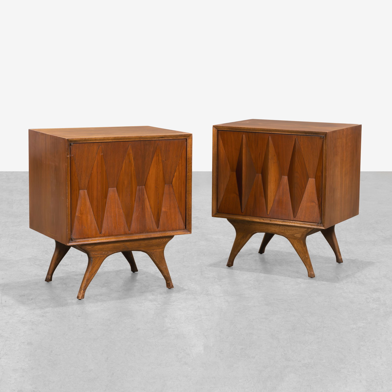 Albert Parvin (Attr.) - Nightstands: A pair of walnut nightstands with faceted doors attributed to Albert Parvin. All measurements are in inches. Height x Width x Depth