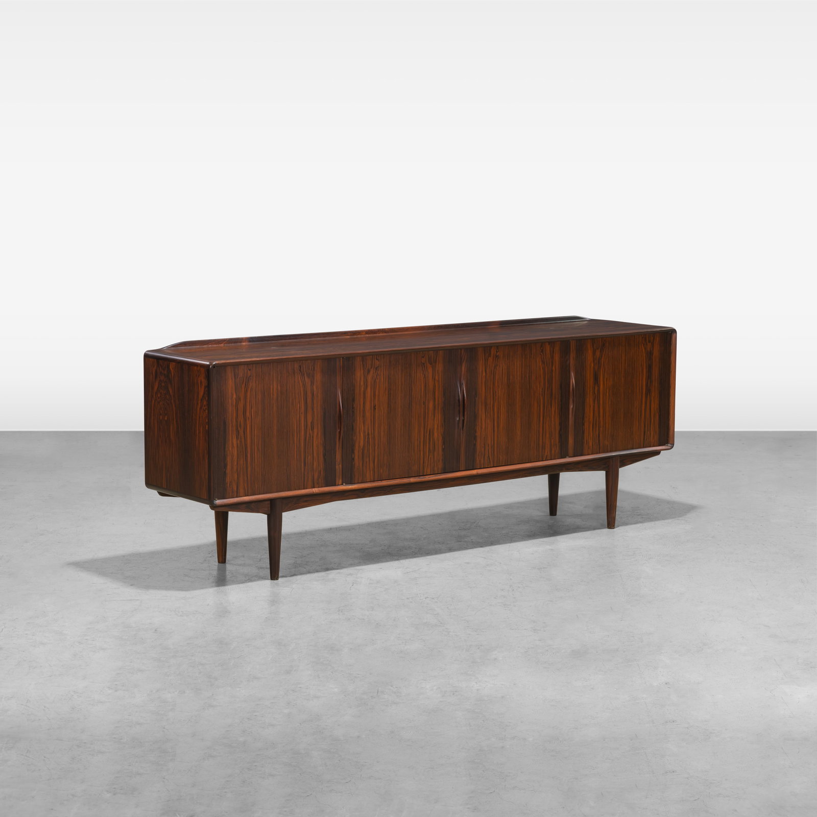 Alf Aarseth - Credenza: A rosewood credenza by Alf Aarseth. Center two doors contain one adjustable shelf. Left door contains three drawers. Right door contains one adjustable half shelf. All measurements are in inches. Heig