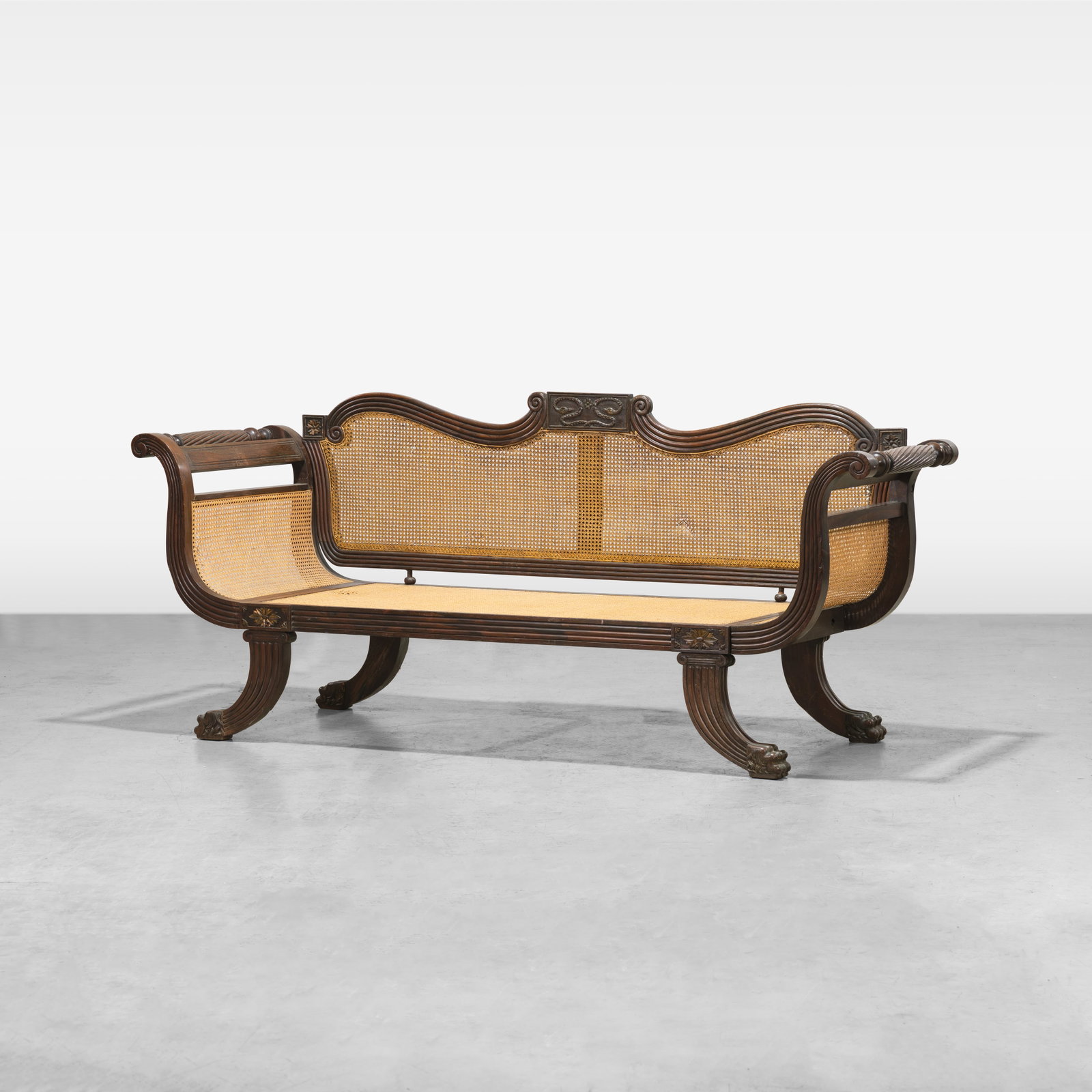Anglo-Indian Settee: A carved mahogany, rosewood, and cane Anglo-Indian settee. All measurements are in inches. Height x Width x Depth