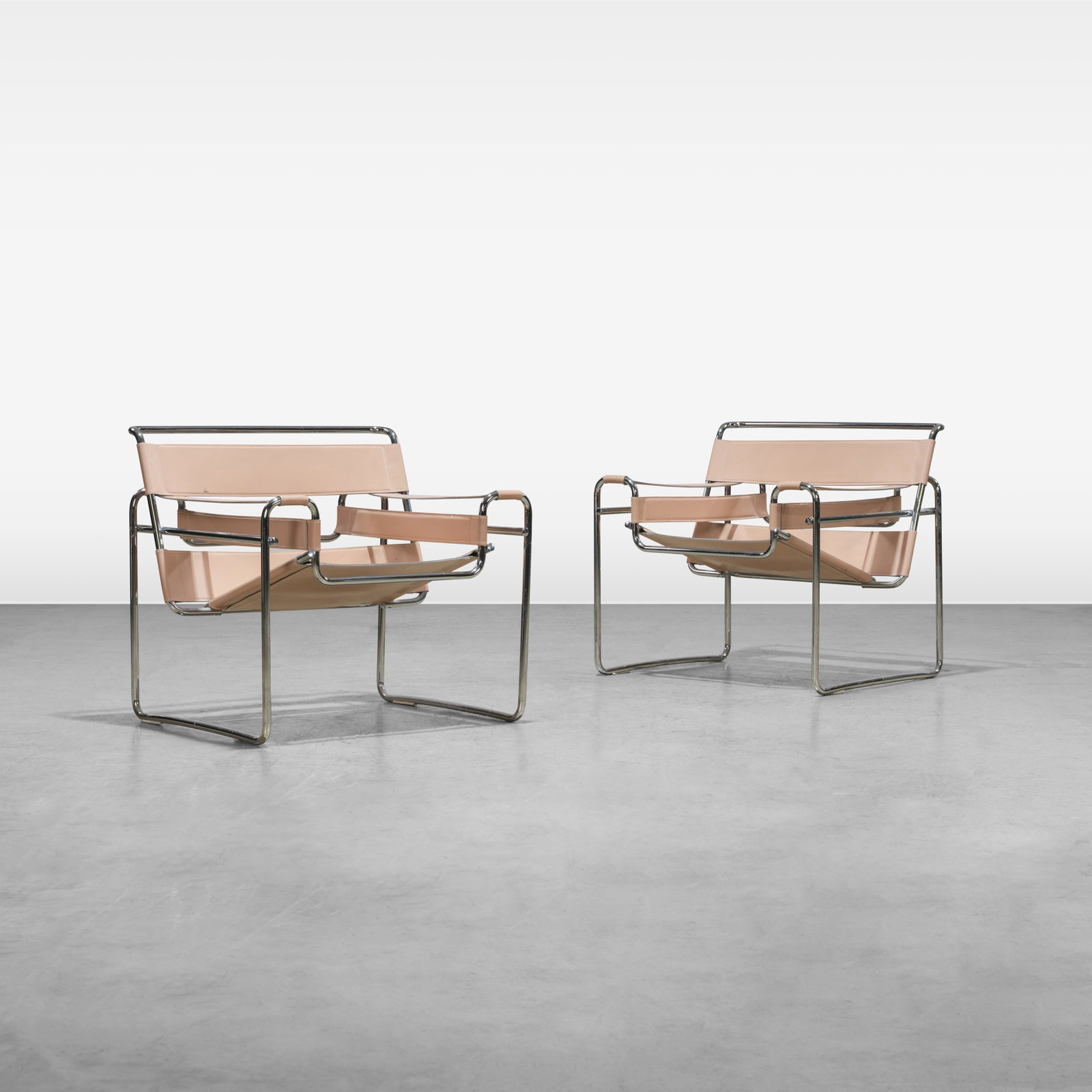 Marcel Breuer (After) - Chairs: A pair of leather and chrome lounge chairs in the style of 'Wassily' chairs by Marcel Breuer. Made in Italy. All measurements are in inches. Height x Width x Depth