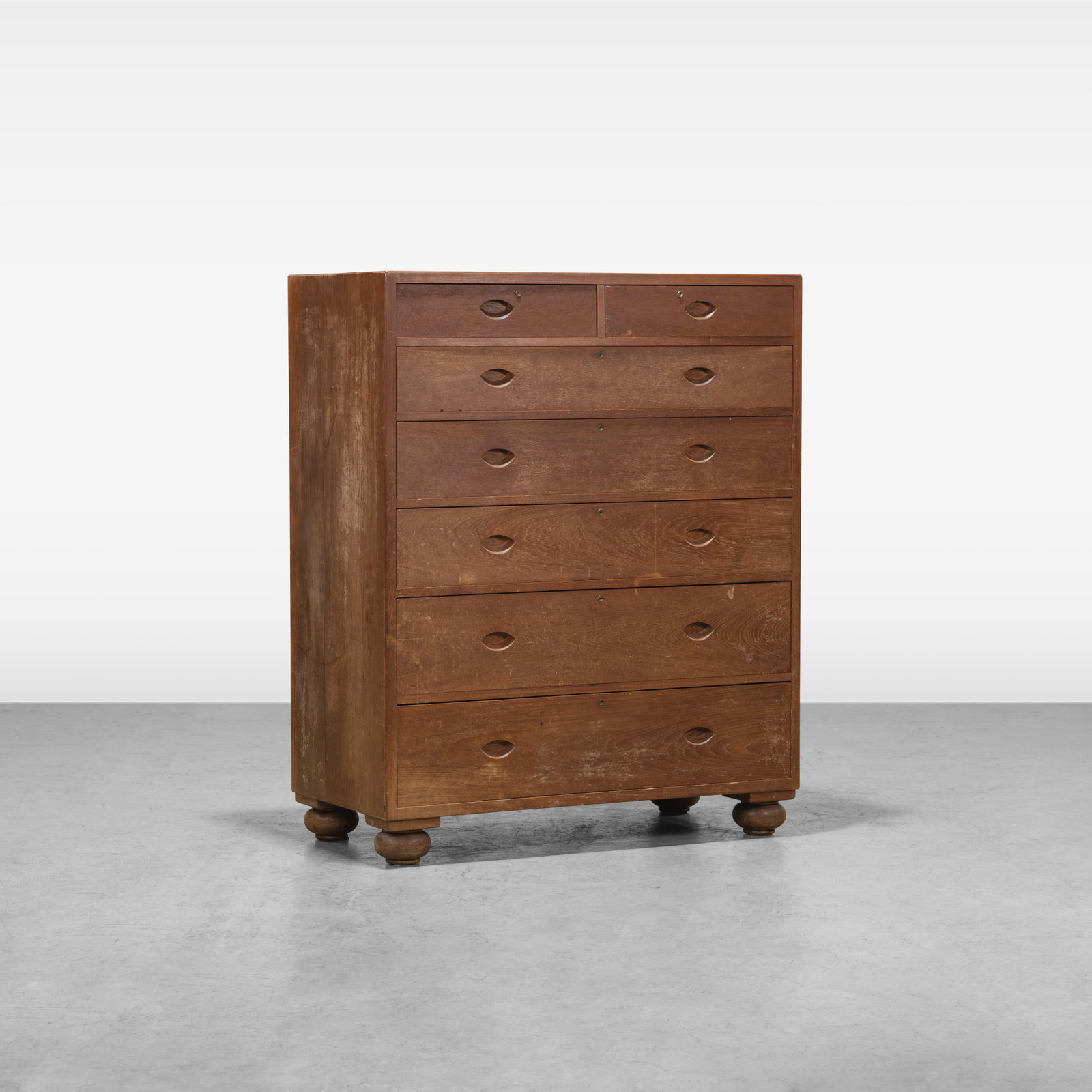 Teak High Chest: A teak high chest on removable brass pinned bun feet. Includes six keys, one for each drawer. All measurements are in inches. Height x Width x Depth