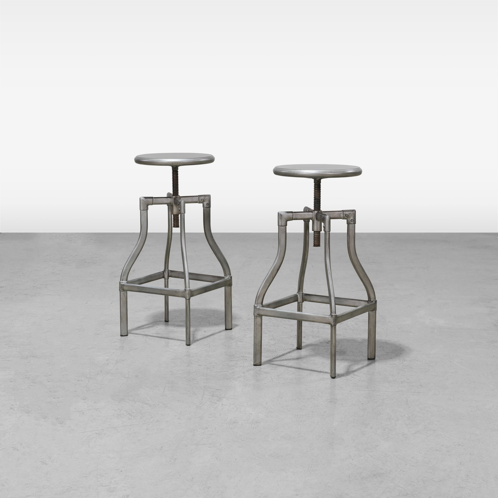Industrial Drafting Stools: A pair of adjustable industrial drafting stools. All measurements are in inches. Height x Width x Depth