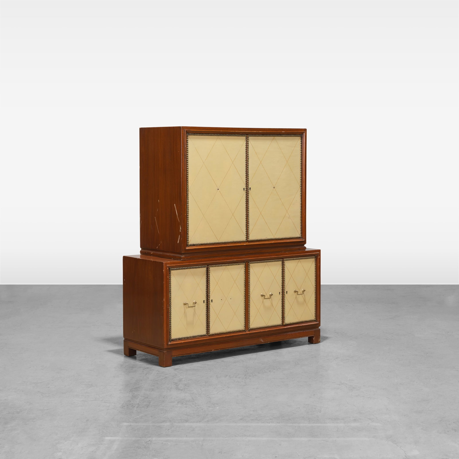 Vintage Cabinet: A vintage two-part cabinet with embossed leather doors in the manner of Tommi Parzinger. Top contains two adjustable shelves. All measurements are in inches. Height x Width x Depth