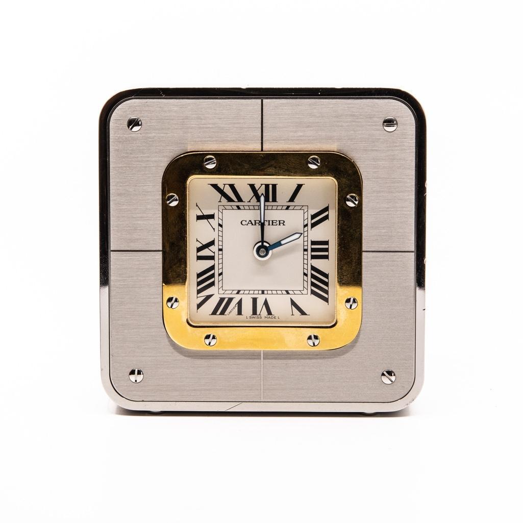 Cartier "Santos" Alarm Clock: Cartier Santos alarm desk clock steel with a gold plated bezel and luminous hands. The clock has not been tested. It has very minor scratches but overall it is in good condition. It is accompanied by