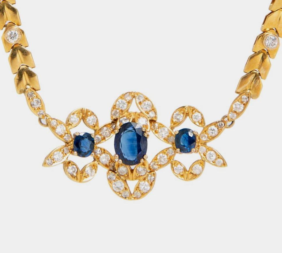 GIA Yellow Gold, Sapphire and Diamond necklace: A Yellow Gold, Sapphire and Diamond necklace containing one oval shape mixed cut sapphire measuring approximately 9.00 x 6.95 x 3.20 mm, two oval shape mixed cut sapphires and 66 round brilliant cut d