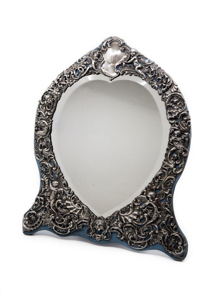 Sterling Silver Standing Dresser Mirror: London sterling silver standing mirror, elaborate repousse work with beveled heart shaped mirror,silk backing circa 1895 bears London hallmarks for 1895 and maker mark W.C. approx 18". Please look clo