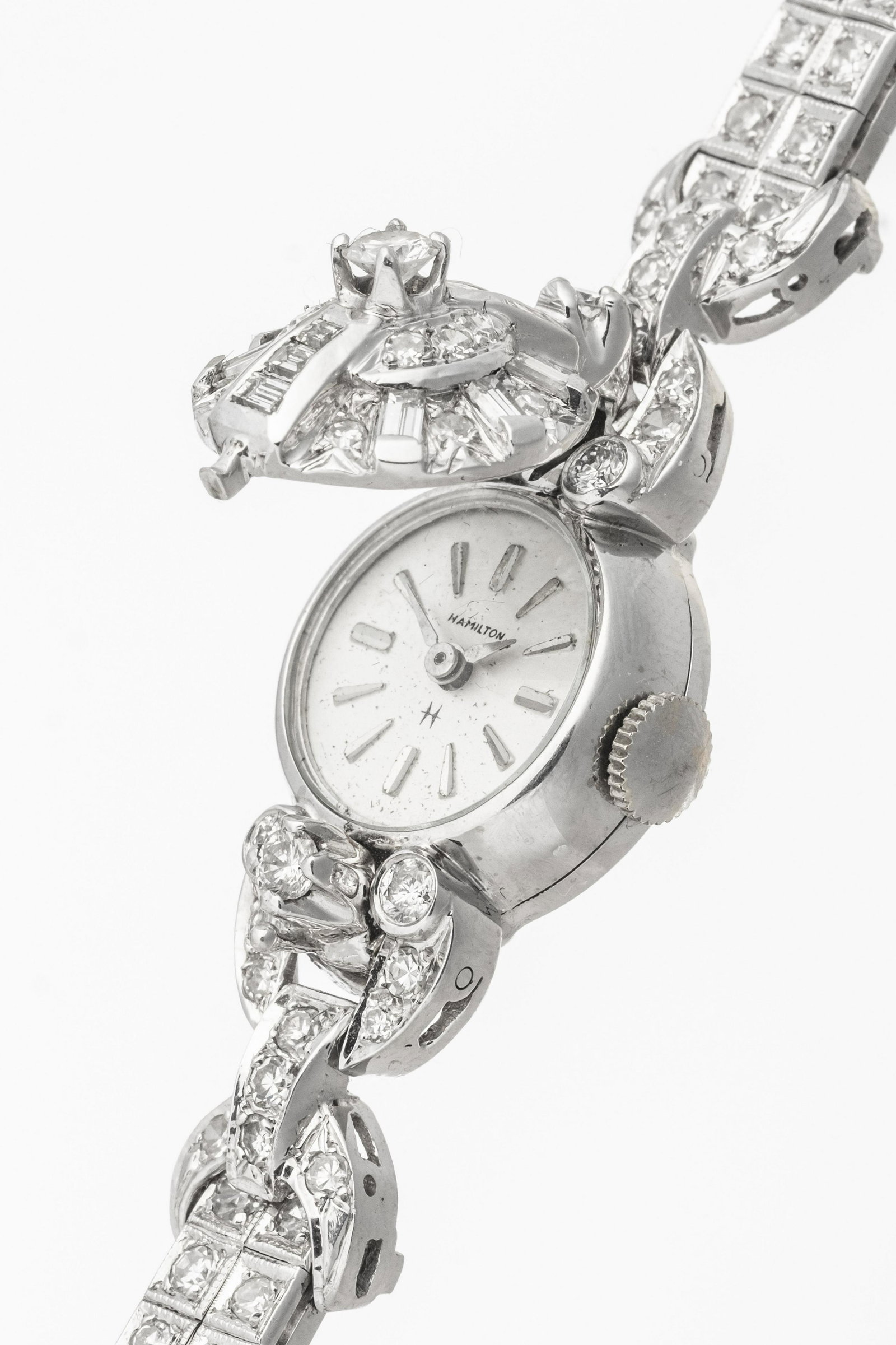 A DIAMOND AND FOURTEEN KARAT WHITE GOLD HIDDEN HAMILTON WATCH BRACELET: A DIAMOND AND FOURTEEN KARAT WHITE GOLD HIDDEN HAMILTON WATCH BRACELET One lady's 14k white gold, 7 inch long, fashion wristwatch manufactured by the Hamilton Watch Company. The name, "Hamilton&q