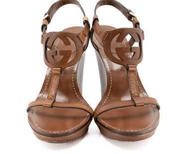 Gucci Tan Leather Interlocking GG T-Strap Wedge Sandals: Keywords: Italian fashion, designer sandals, summer shoes, women’s footwear, fashion, accessoriesTan leather wedge sandals by Gucci featuring a T-strap design with iconic interlocking GG logo.Keywor